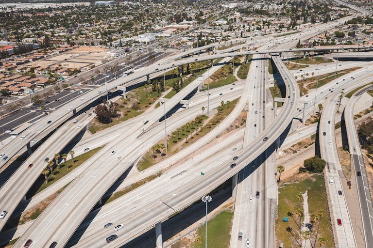 A high-angle aerial shot of a sprawling urban highway interchange with light traffic.